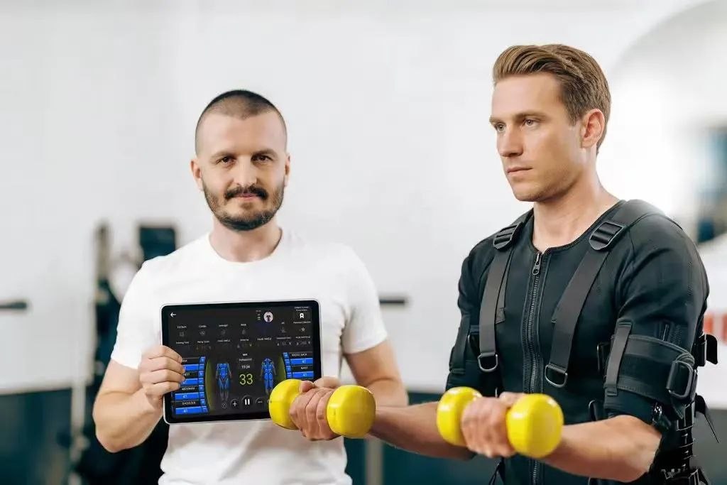 Trainer coaching a client in an Adapt EMS suit